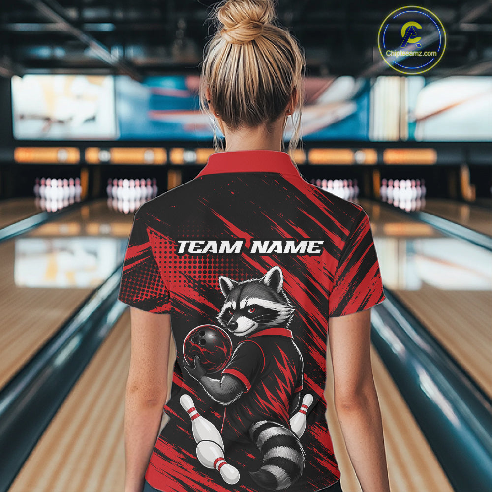 A woman viewed from behind wearing a short-sleeve bowling quarter zip shirt with a raccoon graphic and 'TEAM NAME' text on the back, standing in a bowling alley.