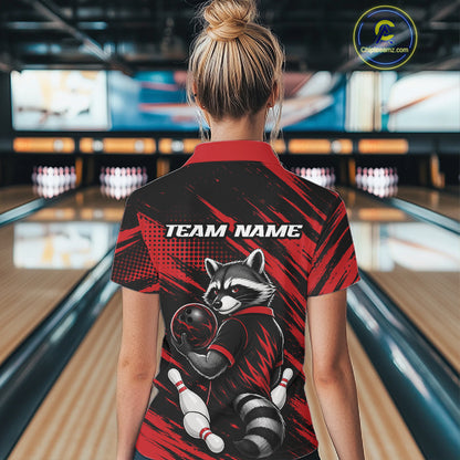 A woman viewed from behind wearing a short-sleeve bowling quarter zip shirt with a raccoon graphic and 'TEAM NAME' text on the back, standing in a bowling alley.