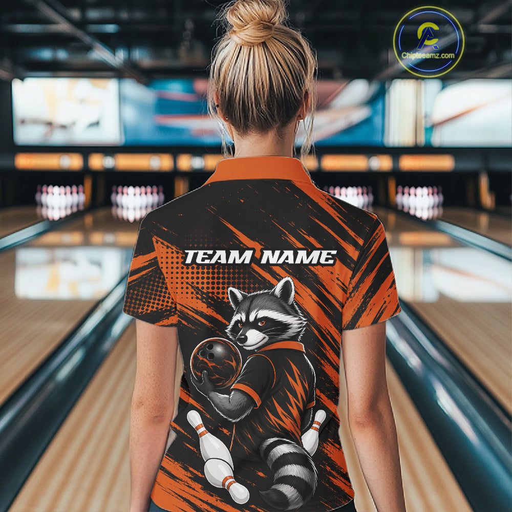 A woman viewed from behind wearing a short-sleeve bowling-themed quarter zip shirt with a raccoon graphic and 'TEAM NAME' text on the back, standing in a bowling alley.