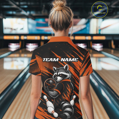 A woman viewed from behind wearing a short-sleeve bowling-themed quarter zip shirt with a raccoon graphic and 'TEAM NAME' text on the back, standing in a bowling alley.
