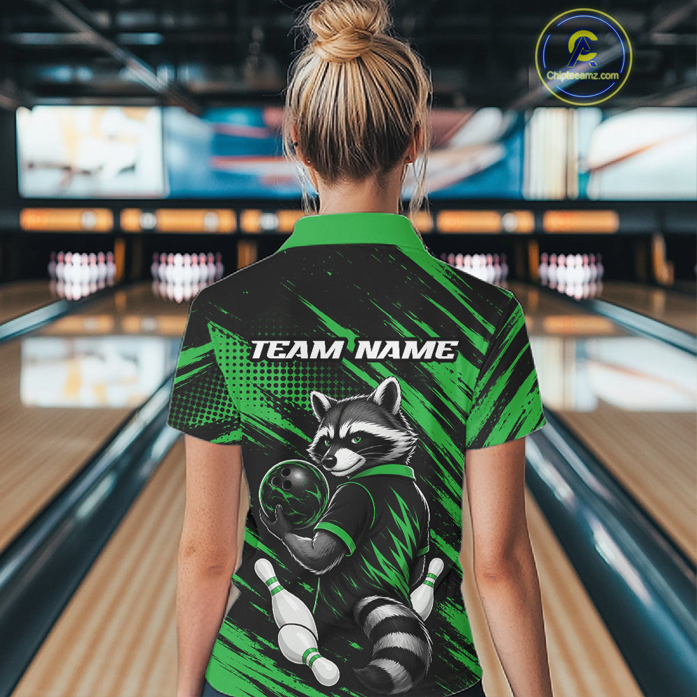 A woman viewed from behind wearing a short-sleeve bowling shirt with a raccoon graphic and 'TEAM NAME' text, standing in a bowling alley. The shirt is black and bright green with a raccoon illustration and bowling pins.