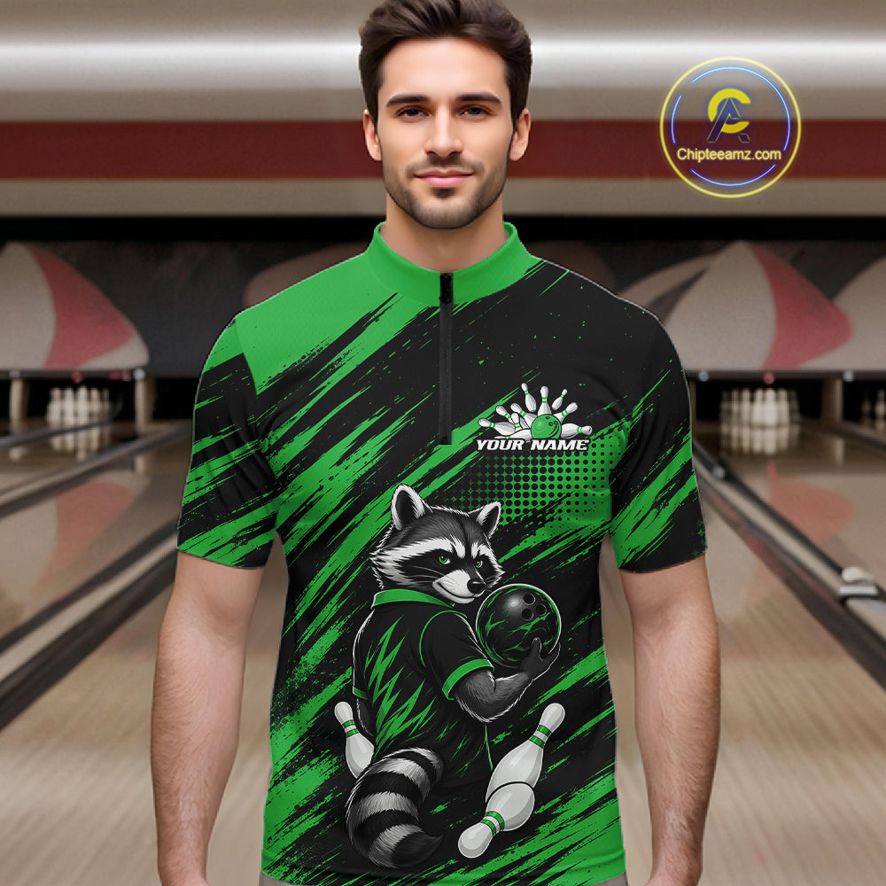 A man wearing a short-sleeve quarter-zip bowling jersey with a green and black raccoon graphic, set against a blurred bowling alley background.