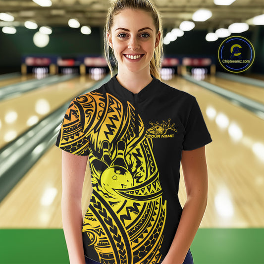 Female model wearing a black and gold bowling quarter-zip shirt at the lane with Polynesian-style bowling artwork.