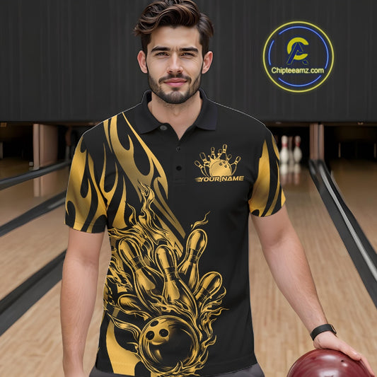 Male model seen from the front in a bowling lane wearing a black polo shirt featuring a golden metal tribal flame bowling ball striking pins in a dynamic action scene.