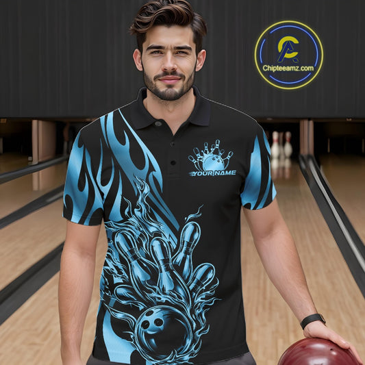 Male model seen from the front in a bowling lane wearing a black polo shirt featuring a blue gradient tribal flame bowling ball striking pins in a dynamic sports action scene.