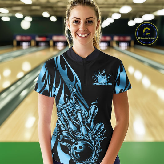 Female model front view at bowling lane wearing black quarter zip shirt with blue gradient flame bowling strike themed artwork