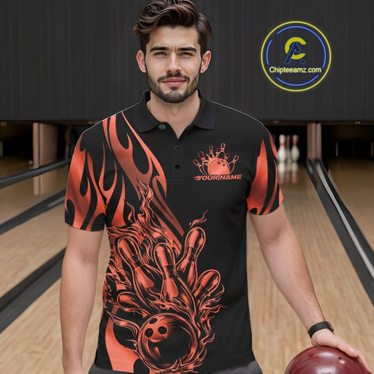 Male model seen from the front in a bowling lane wearing a black polo shirt featuring a red gradient tribal flame bowling ball striking pins in a dynamic action scene.