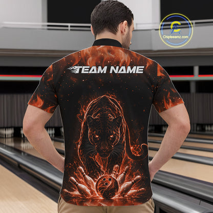 Front view of a male model in a bowling lane wearing a black quarter-zip shirt featuring glowing orange electric panther artwork with bowling ball striking pins.