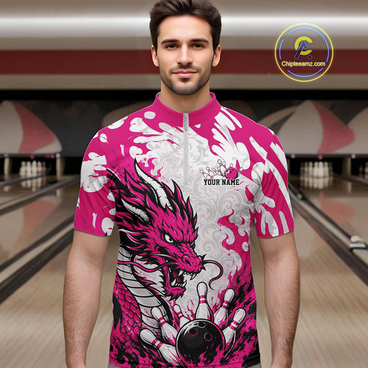 Man wearing a pink and white bowling shirt with a dragon design in a bowling alley.