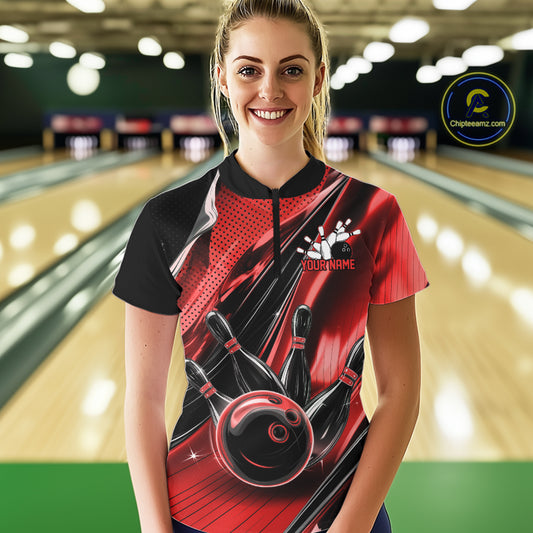 Female model wearing a black and red bowling quarter-zip shirt at the bowling lane with fast-moving bowling ball and pin graphics.