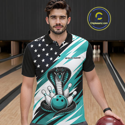 A smiling man stands in a bowling alley wearing a black, white, and blue bowling shirt with stars, diagonal stripes, a cobra, pins, and an blue ball.