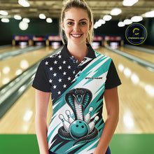 Load image into Gallery viewer, A woman stands in a bowling alley wearing a black, white, and blue bowling shirt with stars, diagonal stripes, a cobra, pins, and an blue ball.