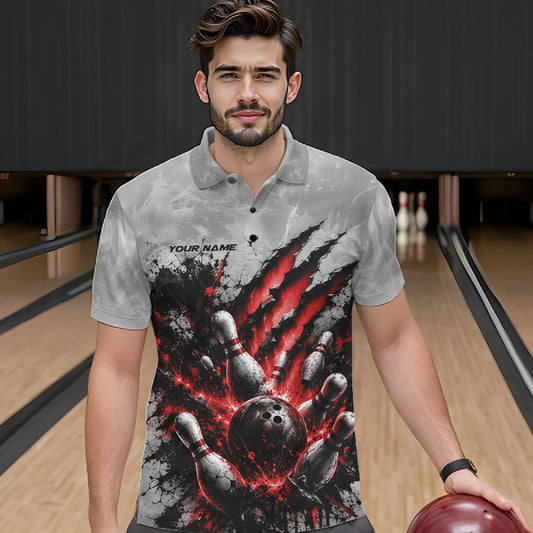 Front view of a male model wearing a gray bowling polo shirt featuring a dramatic red bowling ball and pins graphic with claw-mark artwork in a bowling lane.