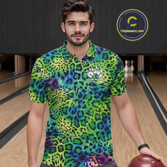 A man stands in a bowling alley wearing a yellow, brown, and black leopard-print bowling shirt with a bowling pin graphic and “Your Name” on the chest.