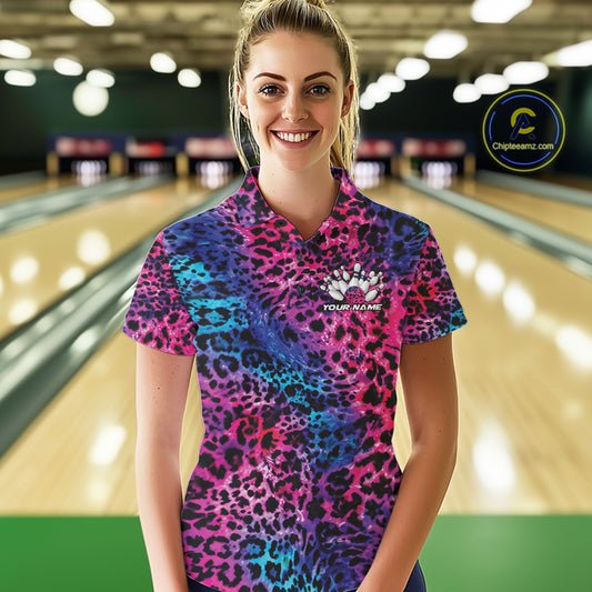 Smiling woman in a bowling alley wearing a gold, brown, and black leopard-print bowling polo with a small bowling pins graphic and “Your Name” on the chest.