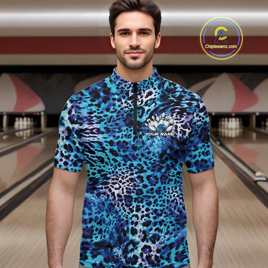 Man in a bowling alley wearing a blue, teal, and black leopard-print bowling quarter zip shirt with “Your Name” and a bowling pins graphic on the chest.
