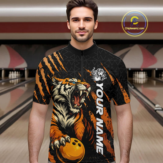 Male model wearing a black and yellow bowling quarter-zip shirt in a bowling lane, showcasing a roaring tiger holding a yellow bowling ball with orange claw-stripe graphics and a geometric background pattern.