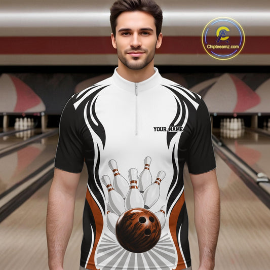 Front view of a male model wearing a white, black, and orange bowling quarter-zip shirt featuring bowling ball hitting the pins artwork inside a bowling center.