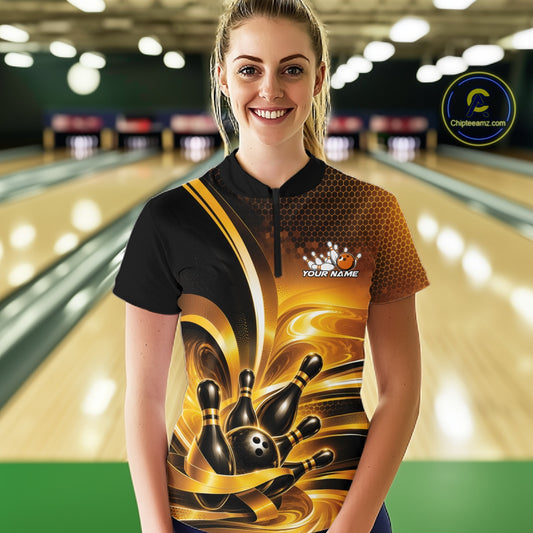Front view of a female model at a bowling lane wearing a bowling quarter-zip shirt with glossy gold and black bowling ball and pins artwork.
