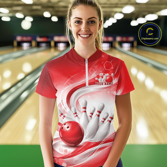 At the bowling lane, a female model wears a white and red bowling quarter-zip featuring wave-inspired graphics and bowling-themed artwork