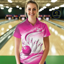 Load image into Gallery viewer, Female model standing in a bowling lane wearing a white and pink bowling polo shirt featuring abstract wave lines and a glossy bowling ball striking pins on the front.