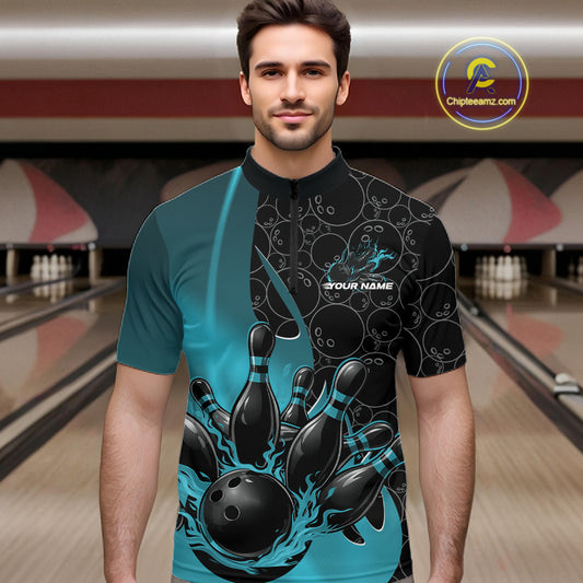 Male model front view at bowling lane wearing black and blue quarter zip shirt with fiery bowling ball graphic and pins impact scene