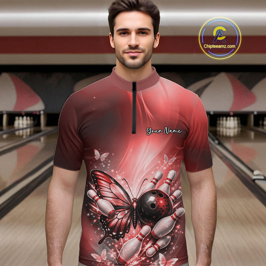 Male model at a bowling lane wearing a red bowling quarter-zip shirt with butterfly artwork, a bowling ball, and pin graphics.