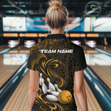 Load image into Gallery viewer, Back view of a female model wearing a black and yellow bowling polo shirt in a bowling alley featuring a tribal flame bowling ball and pins graphic
