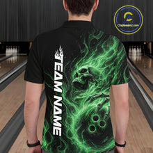 Load image into Gallery viewer, Back view of a male model wearing a black bowling polo shirt in a bowling alley featuring a skull clutching a bowling ball with swirling green energy flames