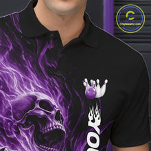 Load image into Gallery viewer, Close-up of the left chest on a black bowling polo shirt featuring a skull clutching a bowling ball surrounded by swirling purple energy flames