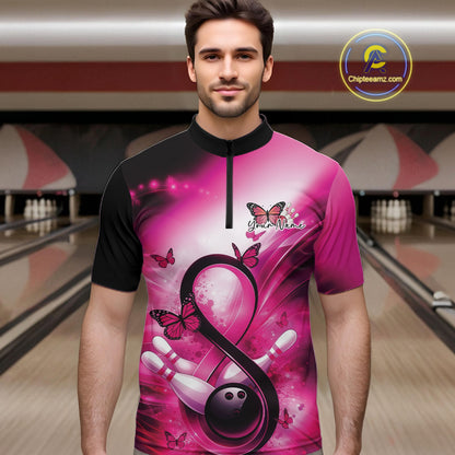 Male model in a bowling alley wearing a quarter-zip shirt with a pink ribbon, bowling ball, and butterfly illustration.
