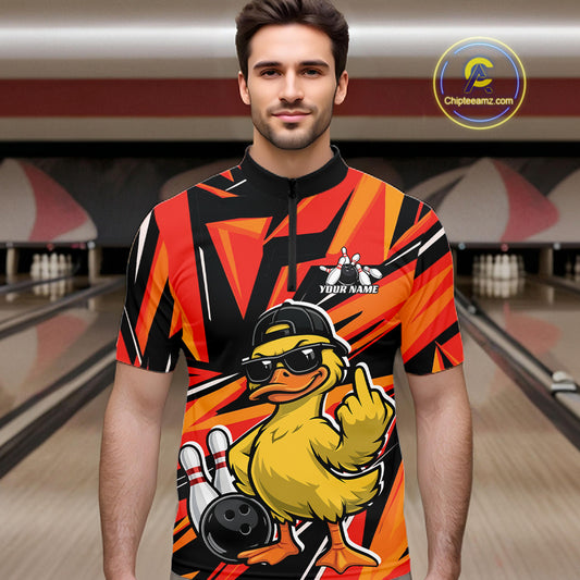 Male model at a bowling alley wearing a black and orange quarter-zip featuring a duck in sunglasses and cap beside bowling elements.