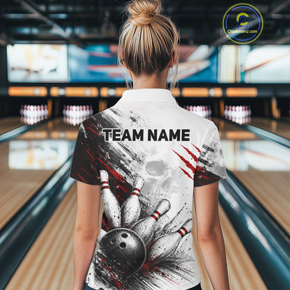 A woman viewed from behind wearing a bowling-themed short-sleeve collared shirt with a white base and a graphic of bowling pins, a bowling ball, and red claw marks. The background shows blurred bowling lanes.