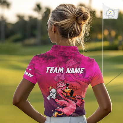 A woman on a golf course seen from behind, wearing a bright pink and purple short-sleeve collared golf shirt with a flamingo graphic and the words 'TEAM NAME' across the back.