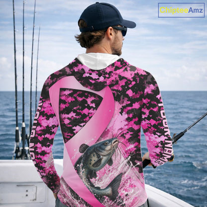 Angler wearing pink ribbon camouflage catfish fishing breast cancer long sleeve hooded sun protection shirt on the water