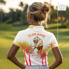Load image into Gallery viewer, Woman wearing a funny duck womens golf polo with tropical sunset and 'Team Name' text on the back, standing on a golf course.