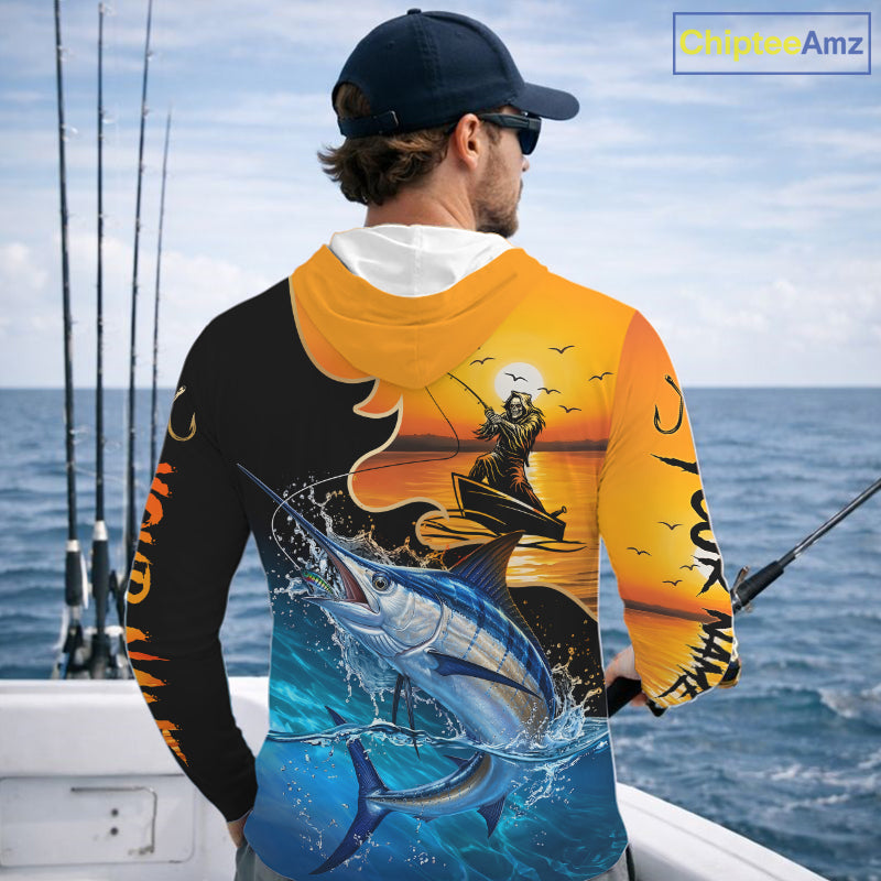 Person wearing a saltwater long sleeve hooded fishing shirt with a sunset and fish reaper design, standing on a boat.