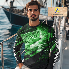 Load image into Gallery viewer, Man wearing a long sleeve fishing shirt with a green bass fish design on a boat