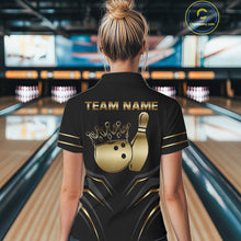 Load image into Gallery viewer, Back view of woman wearing a black and gold crown bowling ball polo shirt inside a bowling alley.